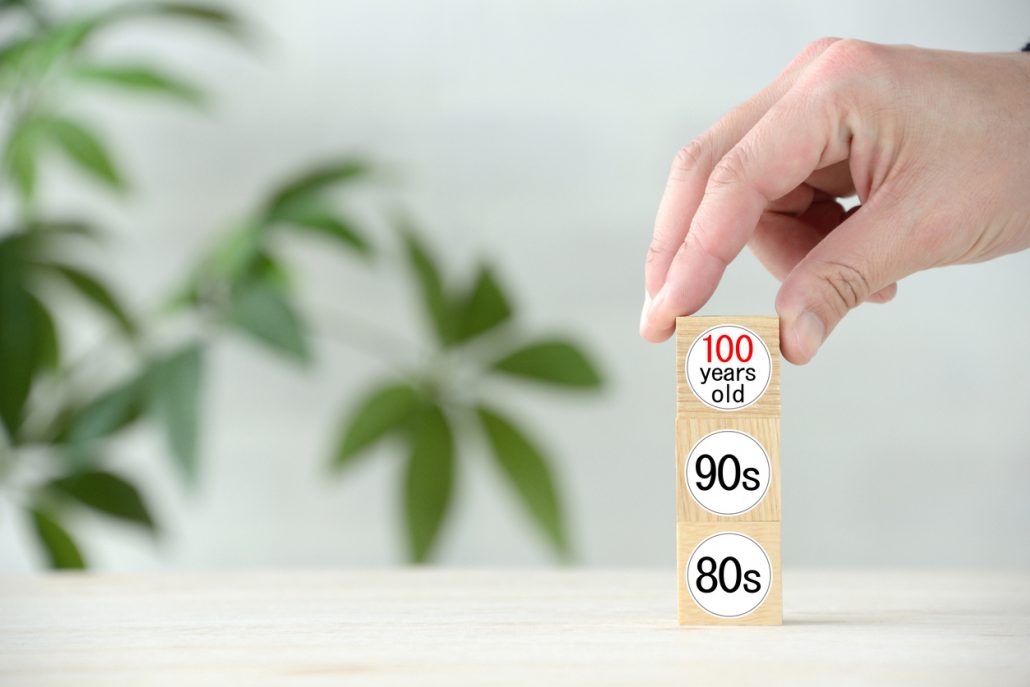 Photo of three age numbers, 80s, 90s, 100s, representing the longevity of Ikarian people. The island of Ikaria is known for its secrets to long and healthy living, including a healthy diet, strong social bonds, midday naps, and a laid-back lifestyle